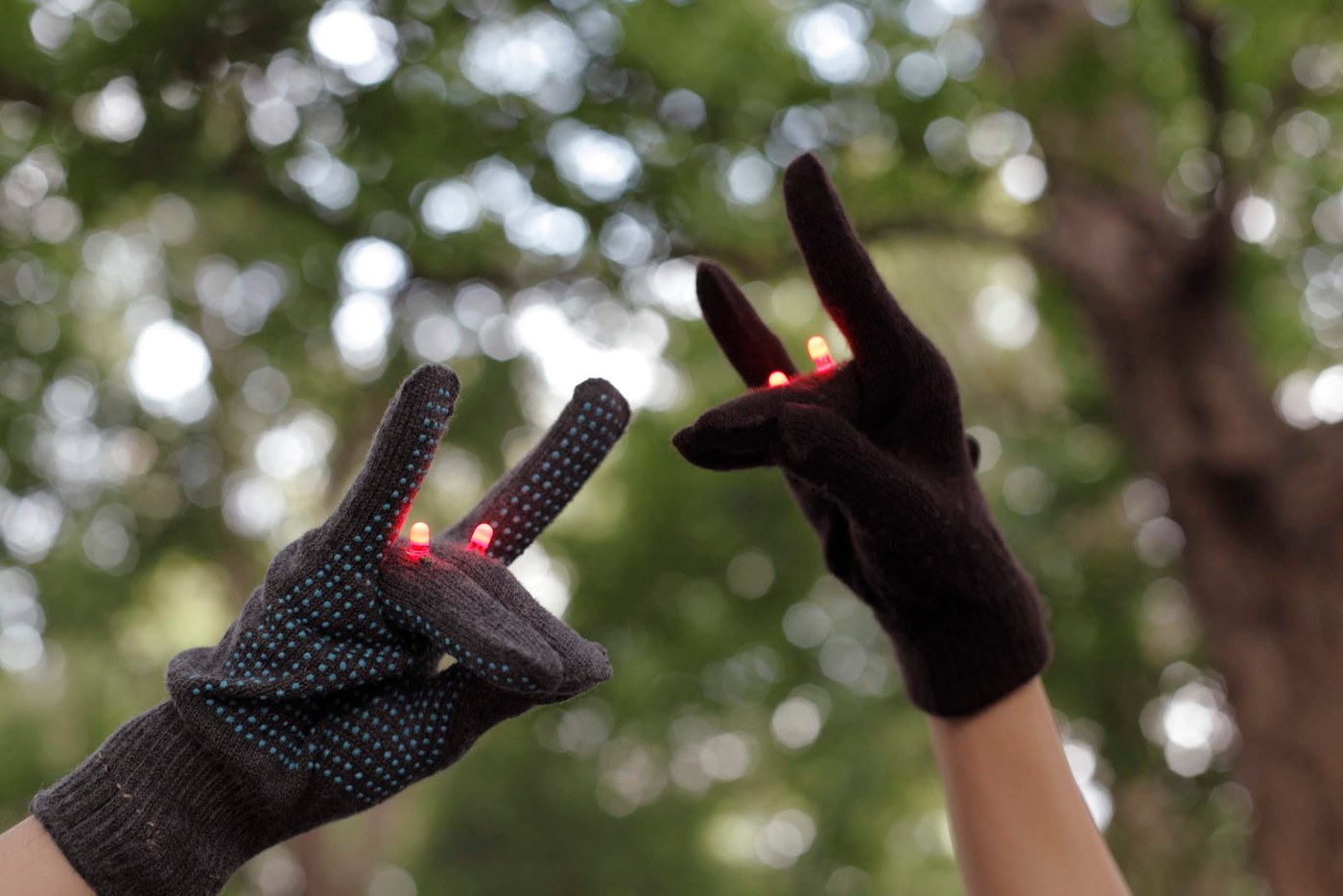 両手にはめた2つのキツネの手袋、どちらもLEDが光っている