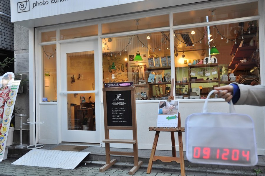 写真店の前でかばんを持っている様子