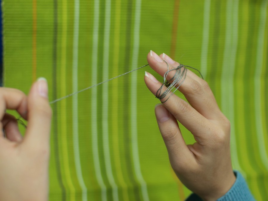 Winding conductive thread around a finger while sewing