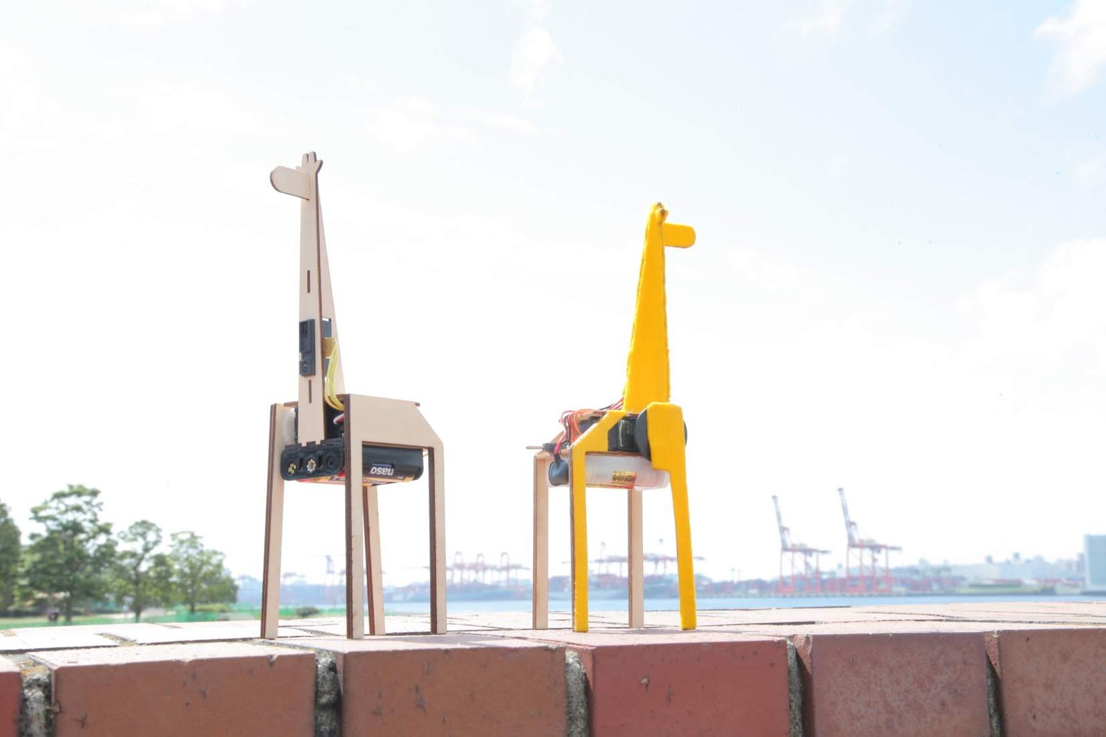 Two giraffes standing on a brick wall